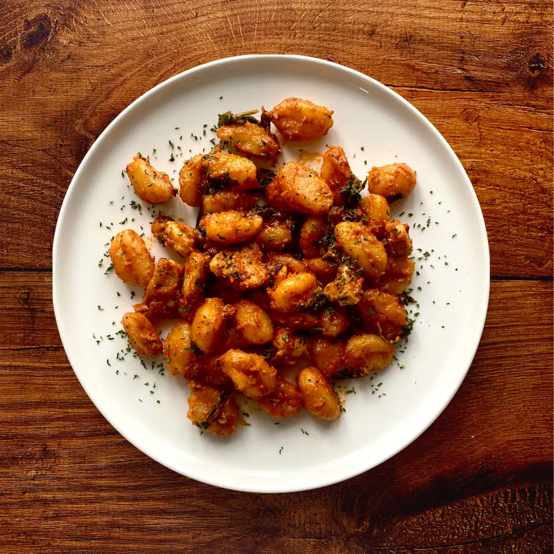 a plate of red pesto chicken gnocchi